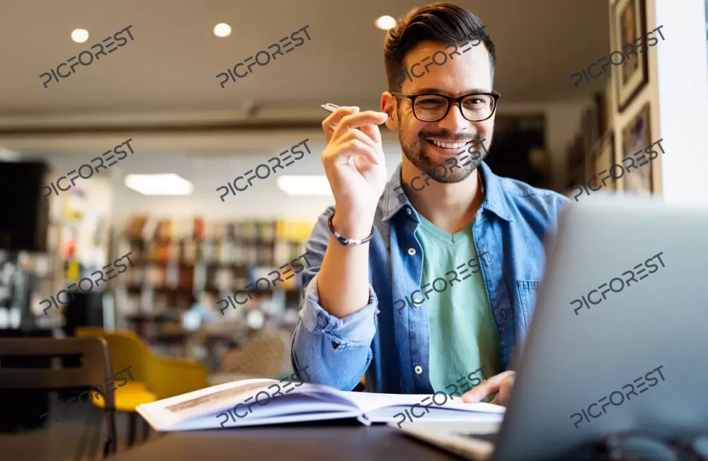 دانلود عکس مرد جوان در حال مطالعه در کتابخانه